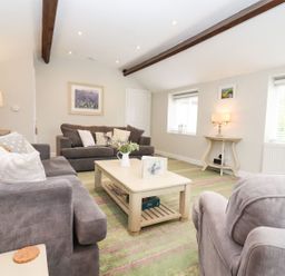 A living room with sofas and a coffee table at Peewit Barn in Moreton-in-Marsh