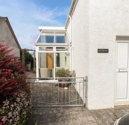 An outdoor area with a gate and door at Hafan y Tyddyn