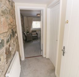 A hallway with a stone wall and access to a room at Hafan y Tyddyn