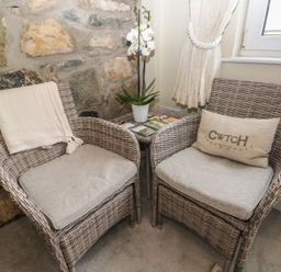 Two chairs with an orchid and a side table at Hafan y Tyddyn
