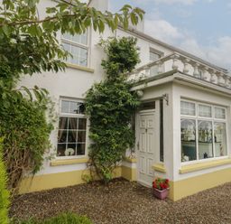 An exterior view of a house with a door and windows at Bruckless Rest Fine Country Dining B&amp;B Bruckless