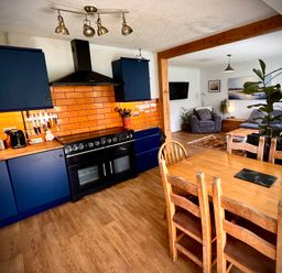 A kitchen with a dining table and a view of a living area at Ty Marlyn St Davids