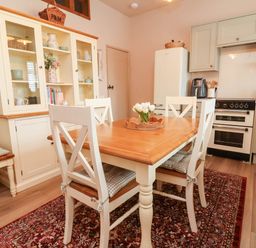 A kitchen with a dining table and chairs at Myrtle Cottage in Lynmouth