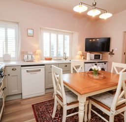 A kitchen with a dining table and appliances at Myrtle Cottage in Lynmouth