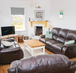 A living room with sofas and a coffee table at Doughbeg Beach Cottage 