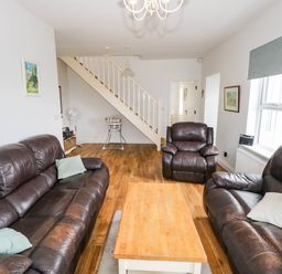 A living room with sofas and a coffee table at Doughbeg Beach Cottage