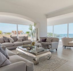 A living room with a sofa, armchair, and coffee table at By The Sea in Newquay