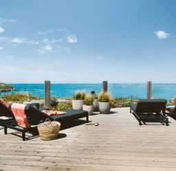 An outdoor area with lounge chairs and planters at By The Sea Newquay