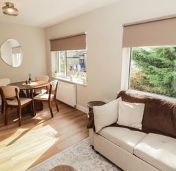 A living room with a round table and chairs at Flat 4 in Tenby