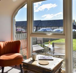 A living room with a window view of outdoor furniture at The Hayloft in Hexham
