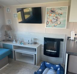 A living room with a television and fireplace at Lyons Sunnysands - Snowdon Summit 050, Talybont