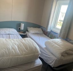 A bedroom with two single beds at Lyons Sunnysands - Snowdon Summit 050 Talybont