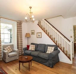 A living room with a sofa and armchair at Jessicas Cottage in Windermere