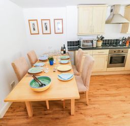 A dining room with a table set for dinner at Basement Apartment in Tenby