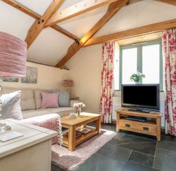 A living room with a sofa and television at Oak Cottage in Truro