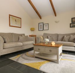 A living room with a sofa and table at Hawthorn Cottage in Truro