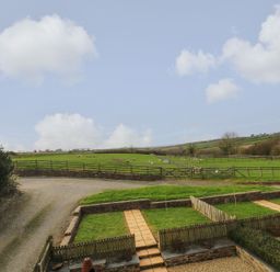 A field with fences and a gravel path at Hawthorn Cottage in Truro