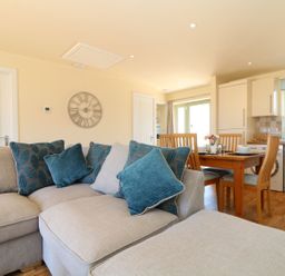 A living room with a sofa and dining area at Elm Cottage in Truro