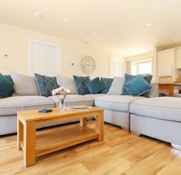 A living room with a sofa and coffee table at Elm Cottage in Truro