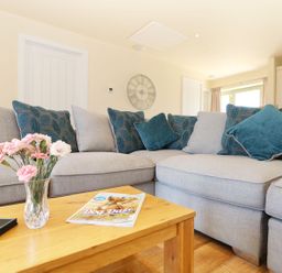 A living room with a sofa and a table at Elm Cottage in Truro