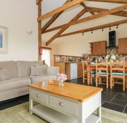 A living room with a sofa and dining area at Ash Cottage in Truro