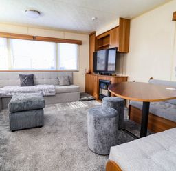 A living room with a television and sofa at Beach Fields 45 in Kinmel Bay