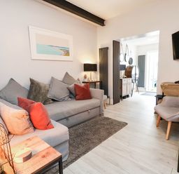A living room with a sofa, table, and decorative items at Flat 1, 2 Wooperton Street Weymouth