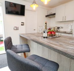 A kitchen with a bar table and chairs at Flat 1, 2 Wooperton Street Weymouth