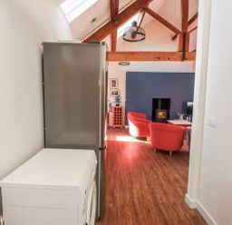 A kitchen with a refrigerator and washing machine at Hen Blas in Pwllheli