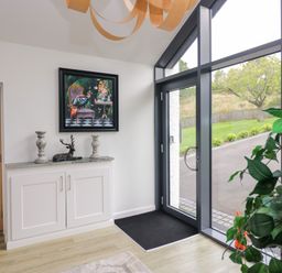 A hallway with a console table and artwork at 10 Rayrigg Rise Bowness-On-Windermere