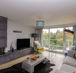 A living room with a television and sofa at 10 Rayrigg Rise Bowness-On-Windermere