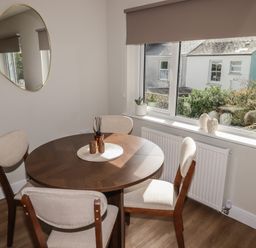 A dining room with a round table and chairs at Flat 2 in Tenby