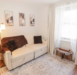 A living room with a sofa and decorative pillows at Flat 3 in Tenby