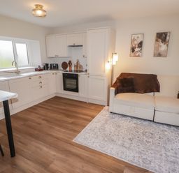 A kitchen with a couch and a dining area at Flat 3 in Tenby