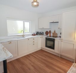 A kitchen with cabinets and appliances at Flat 3 in Tenby