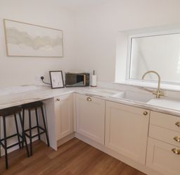 A kitchen with a sink and microwave at Flat 3 in Tenby