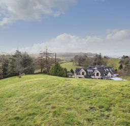 An outdoor view of a house and landscape at High Beck Cottage in Kendal