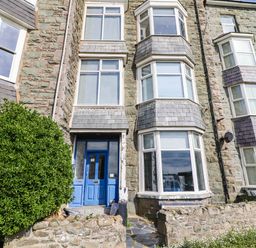A building with blue door and large windows at Flat 4 Greenfields in Barmouth