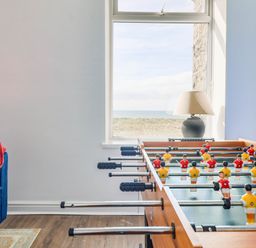 A game room with a foosball table and a sofa at Flat 4 Greenfields Barmouth