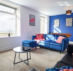 A living room with a blue sofa and coffee table at Flat 4 Greenfields Barmouth