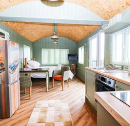 A kitchen with a table and chairs at Calendonia Hut West Mains near Haggerston