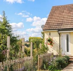 A house with a front door and garden at Merlins Hideaway in Dawlish