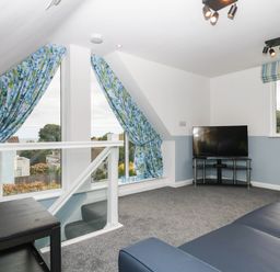 A living room with a television and sofa at Merlins Hideaway in Dawlish