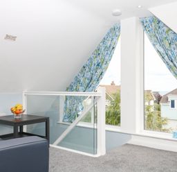 A loft area with a table and fruit bowl at Merlins Hideaway in Dawlish