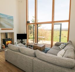 A living room with a sofa and fireplace at Cae Mawr in Caernarfon