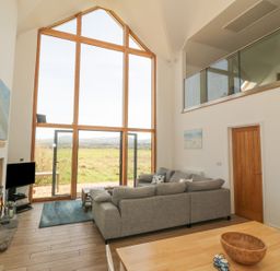 A living room with a sofa and television at Cae Mawr in Caernarfon