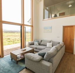 A living room with a sofa and coffee table at Cae Mawr in Caernarfon