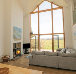 A living room with a sofa and a television at Cae Mawr in Caernarfon