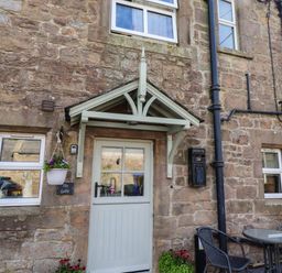 An outdoor area with a front door and seating at The Gables in Alnwick