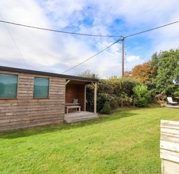 A wooden cabin with a table and chairs in an outdoor space at The Gables in Alnwick